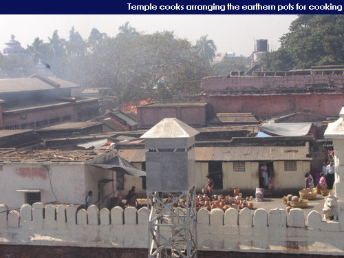 Temple cooks arranging earthern pots for cooking