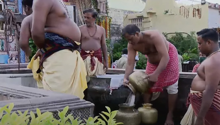 Pani Apata servitors collecting water from a well in front of Chaunni Matha
